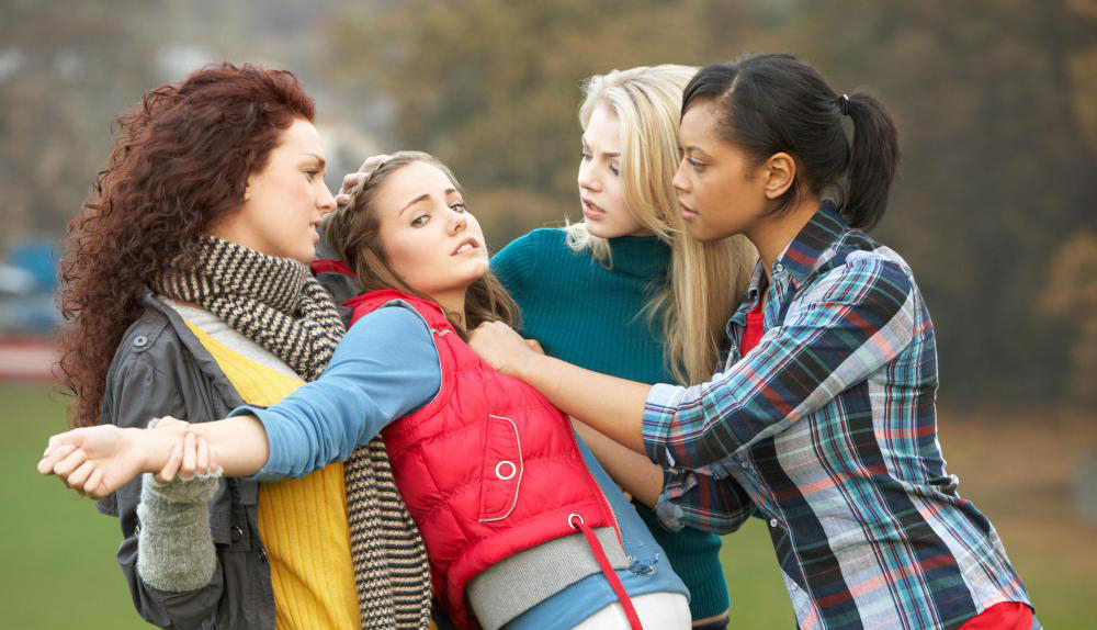 three-girls-ganging-up-on-one-girl-in-red-vest